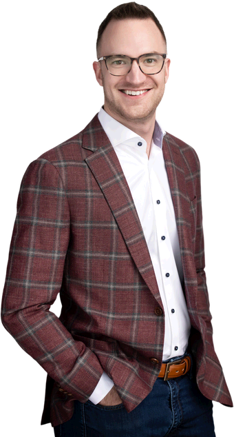 James Green, founder of Dominion AI, standing in a check jacket and open-collar shirt